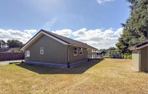 a small house in a yard with a grass yard at Nice Home In Grenaa With Sauna in Grenå