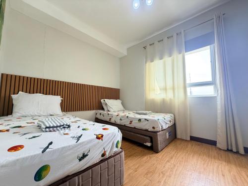 a bedroom with two beds and a window at Compact Studio Unit l Mesaverte Residences 8th Floor in Pontud
