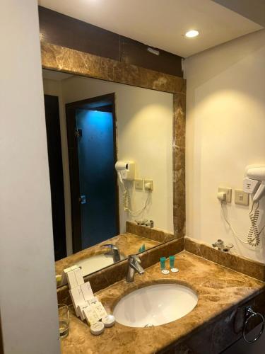 a bathroom with a sink and a large mirror at فندق بياب العزيزية - Beyab Azizia Hotel in Mecca