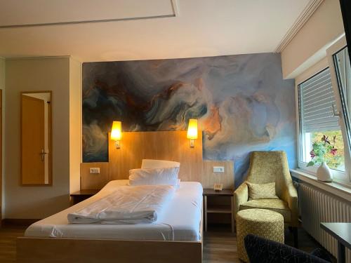 a bedroom with a bed and a painting on the wall at Thermalhotel Kemper in Erwitte