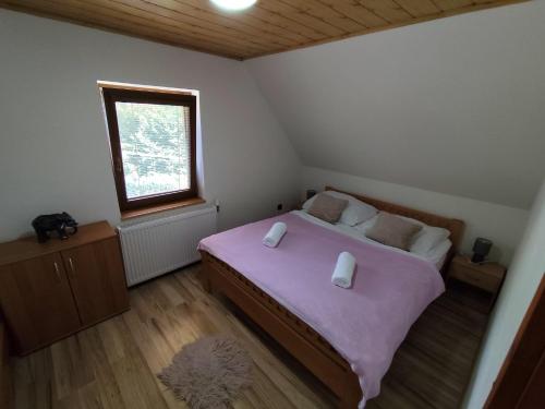 a bedroom with a large bed and a window at Chata Monika Veľké Pole in Veľké Pole