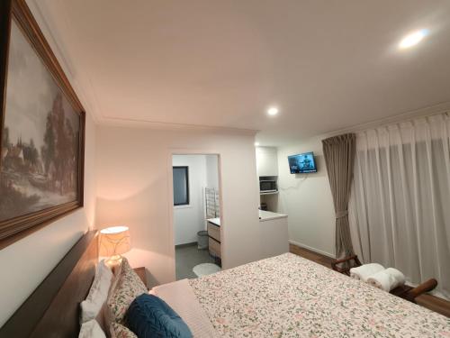 a bedroom with a bed and a desk in it at Private Cozy Sleepout with Free Parking & Self Check-in in Hamilton