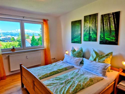 a bedroom with two beds and a window at Ferienwohnung Pickenhan in Scheidegg