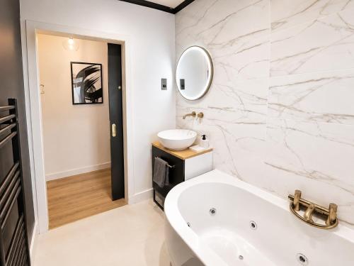 a white bathroom with a tub and a sink at Stylish 2BR House Parking & WiFi Sleeps 6 in Grangemouth