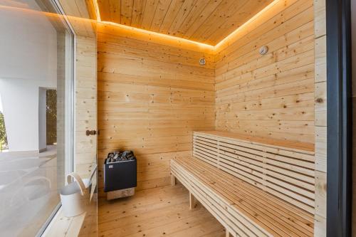 a sauna with wooden walls and a bench at Sunrise - The Twin Villa by PikHost in Shirokë