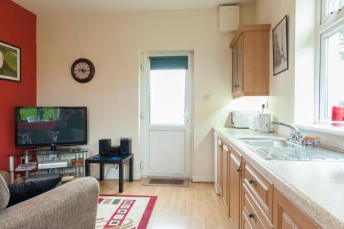 a kitchen with a sink and a tv on a wall at Nick & Sandra's in Slane