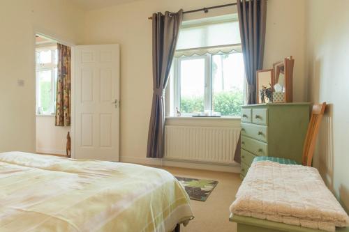 a bedroom with a bed and a window and a dresser at Nick & Sandra's in Slane