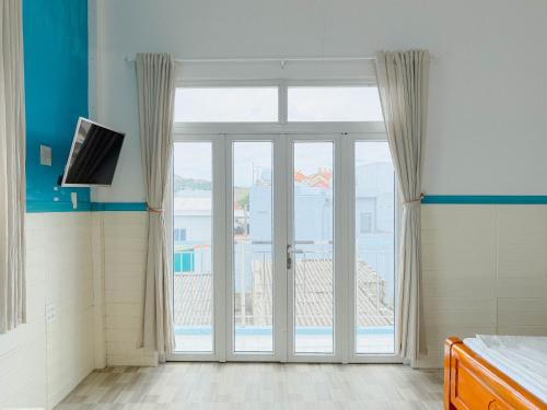 a bedroom with a sliding glass door with a view at Gió Home Nhon Ly in Quy Nhon