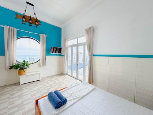 a large room with blue walls and a large window at Gió Home Nhon Ly in Quy Nhon