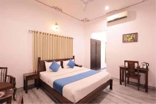 a bedroom with a bed and a table and chairs at Atulya Niwas in Udaipur