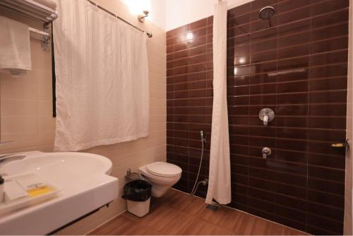 a bathroom with a toilet and a sink and a shower at Atulya Niwas in Udaipur