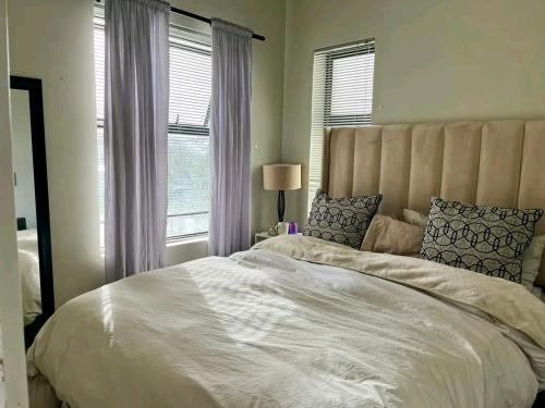 a large white bed in a bedroom with windows at Ocean view in Johannesburg