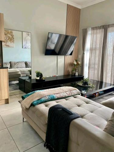 a living room with a couch and a flat screen tv at Ocean view in Johannesburg