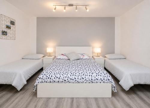a white bedroom with two beds and two lamps at Cozy Apartment with Terrace & Free Parking in Würzburg