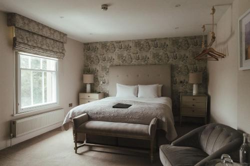 a bedroom with a bed and a chair and a window at Winemaker's Pub in Goudhurst
