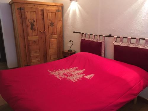 a bedroom with a red blanket on a bed at Agriturismo il Fiocco in Cesana Torinese