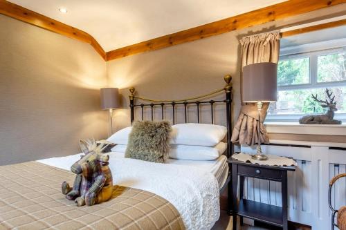a bedroom with a bed with a teddy bear sitting on it at 1 Bed in Callander oc-pe173 in Strathyre