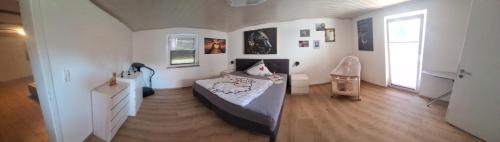 a bedroom with a bed and a dresser in it at Am Fuße des Zoller in Bisingen