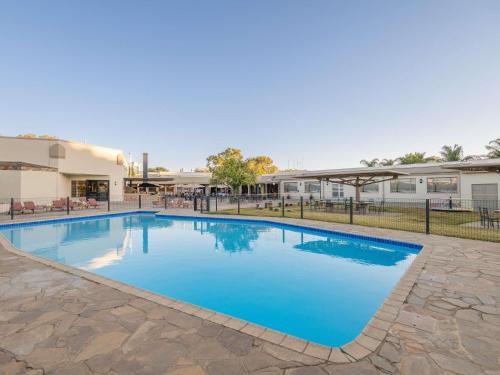 a swimming pool with blue water in front of a building at Mercure Hotel Windhoek in Windhoek