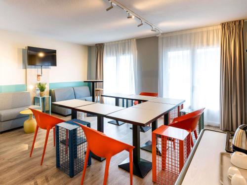 a room with tables and chairs and a living room at ibis Budget Millau Viaduc in Millau