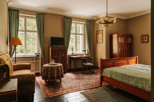 a bedroom with a bed a chair and a desk at Villa Pepita in Miedzygorze
