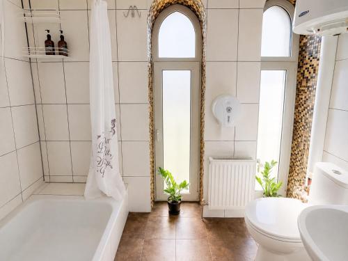 a bathroom with a tub and a toilet and a sink at Family ЛюКс in Kamianets-Podilskyi