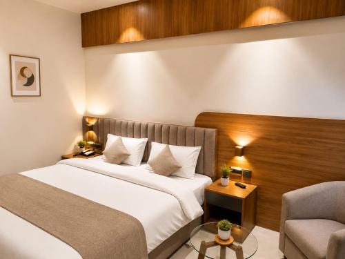 a hotel room with a bed and a chair at The Novaire in Lucknow