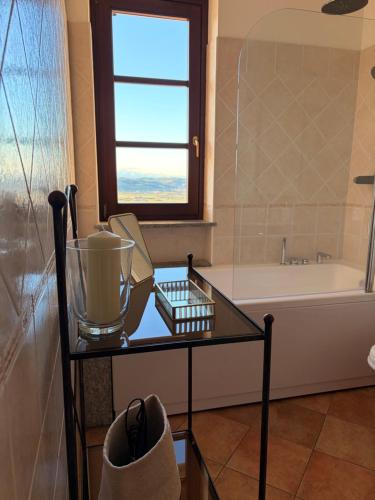 a bathroom with a glass table in front of a tub at Liber Barbaresco House in Barbaresco