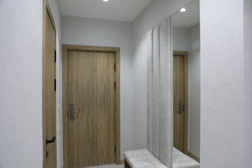 a bathroom with a wooden door and a mirror at Chotqol Sanatorium in G‘azalkent