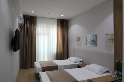 a hotel room with two beds and a window at Chotqol Sanatorium in G‘azalkent