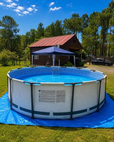 a large circular pool with an umbrella and a house at Luna di Mare in Ureki
