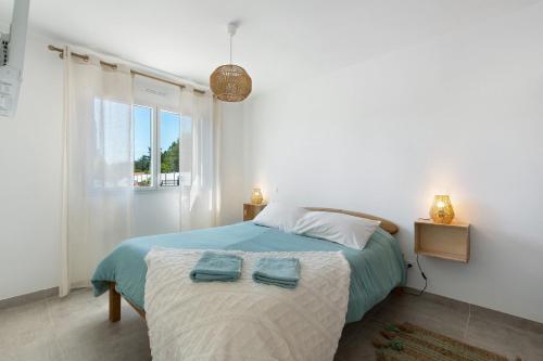 a bedroom with a bed with two towels on it at Maison entre foret et mer in Millebosc