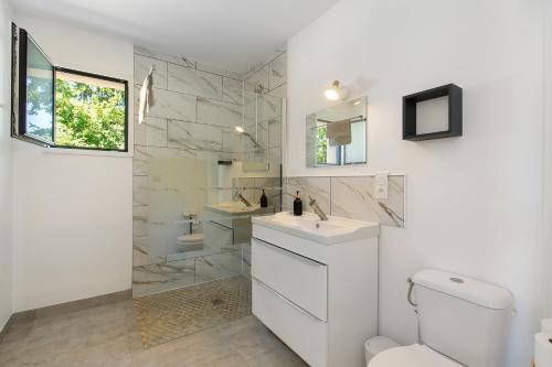 a bathroom with a toilet and a sink and a mirror at Maison entre foret et mer in Millebosc