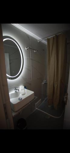 a bathroom with a sink and a mirror and a shower at Ενοικιαζόμενα δωμάτια ΣΟΛΩΝΑΣ in Mytilene