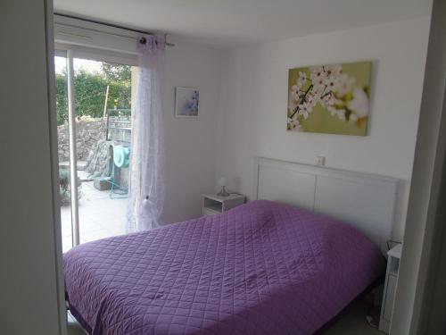a purple bed in a bedroom with a window at Gîte du Manival in Saint-Ismier