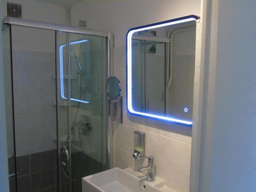 a bathroom with a sink and a shower with a mirror at Gîte du Manival in Saint-Ismier
