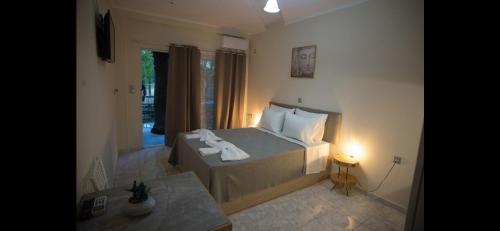 a bedroom with a bed with two towels on it at Ενοικιαζόμενα δωμάτια ΣΟΛΩΝΑΣ in Mytilene