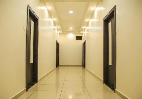 an empty corridor with doors in a building at The Gir Harmony Hotel in Sasan Gir