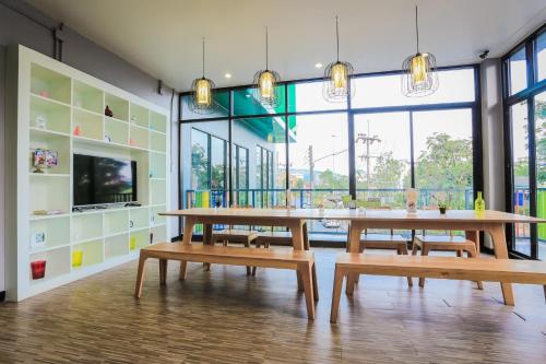 a dining room with wooden tables and benches at The Bedroom in Hat Yai
