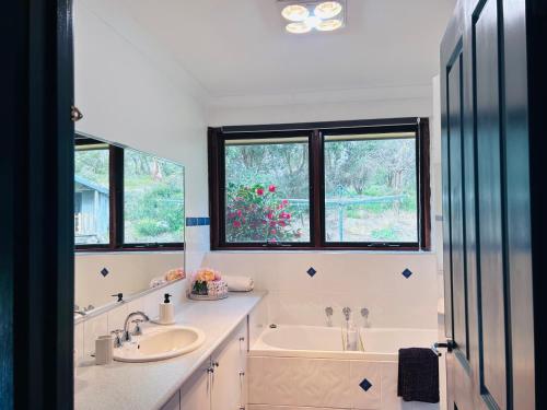 a white bathroom with a tub and a sink at Moon light Retreat in Whittlesea