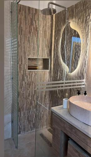 a bathroom with a sink and a glass shower at La perle de bizerte in Bizerte