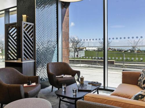 a lobby with couches and chairs and a large window at Mercure Paignton Hotel in Paignton