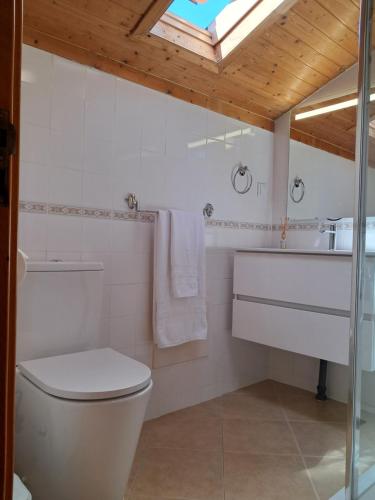 a white bathroom with a toilet and a sink at Casa Vida Alegre in Prazeres
