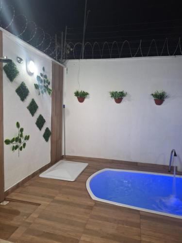 a bath room with a blue tub and potted plants at Casa de 3 Quartos px da Avenida dos Holandeses a 3km da Praia do Araçagy in São Luís