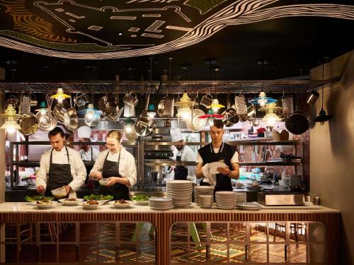 a group of three chefs preparing food in a kitchen at Mama Shelter Dijon in Dijon