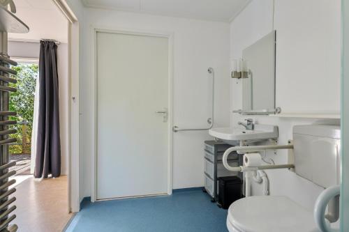 a bathroom with a toilet and a sink at Luwte aan het Lauwersmeer, Friesland in Anjum