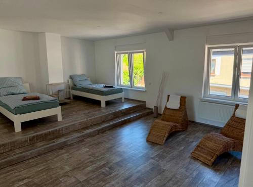 a room with two beds and chairs in it at Apartment im Grünen in Kroppach