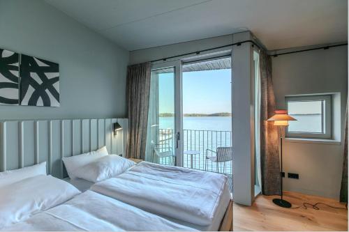 a bedroom with a bed with a view of the water at Im-Jaich Naturoase Gustow in Gustow