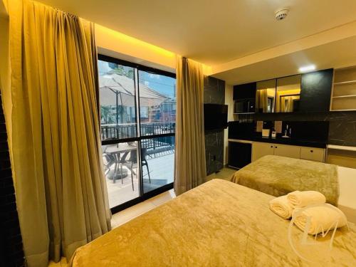 a hotel room with two beds and a large window at LM One Jardim Oceania in João Pessoa