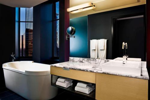 a bathroom with a tub and a sink and a bath tub at W Minneapolis - The Foshay in Minneapolis
